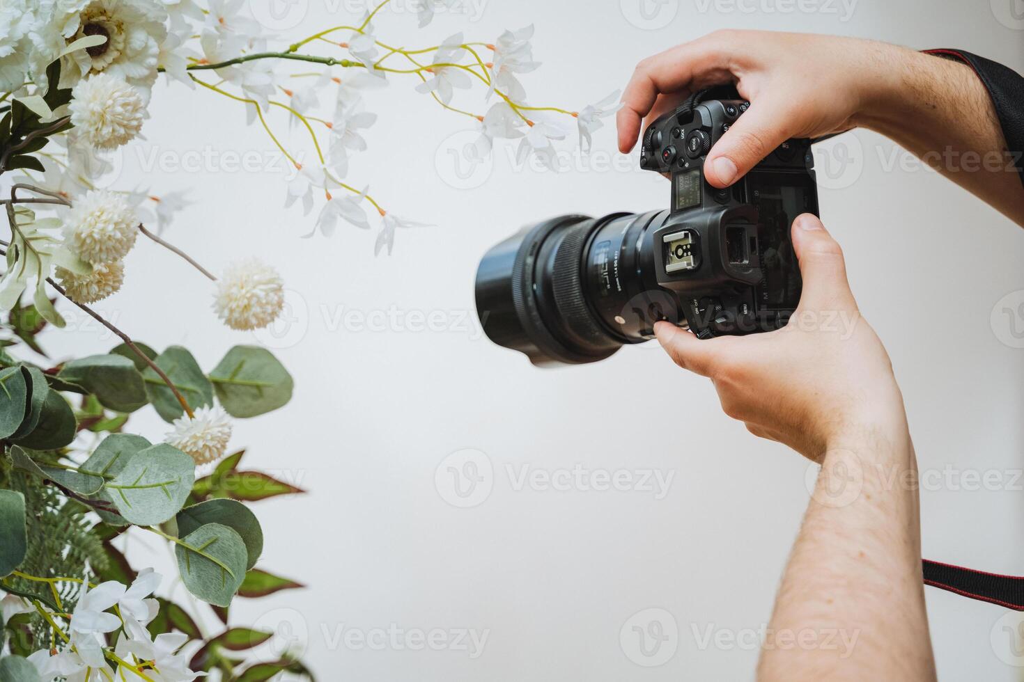 Photographer capturing flowers with digital camera and camera lens photo