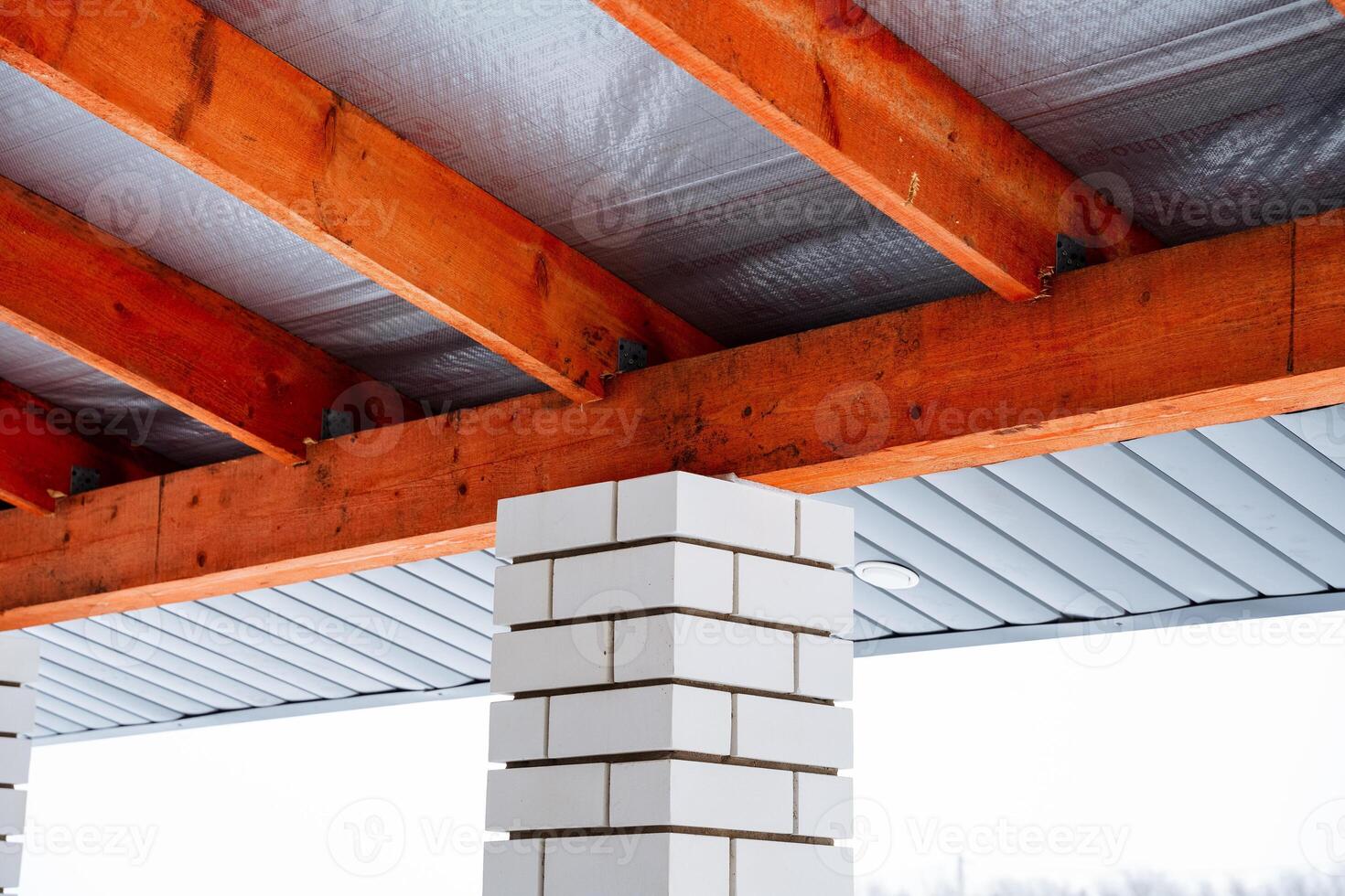 A traditional brick chimney situated beneath a sturdy roof that features beautiful, exposed wooden beams, creating a distinct architectural charm and inviting aesthetic atmosphere photo