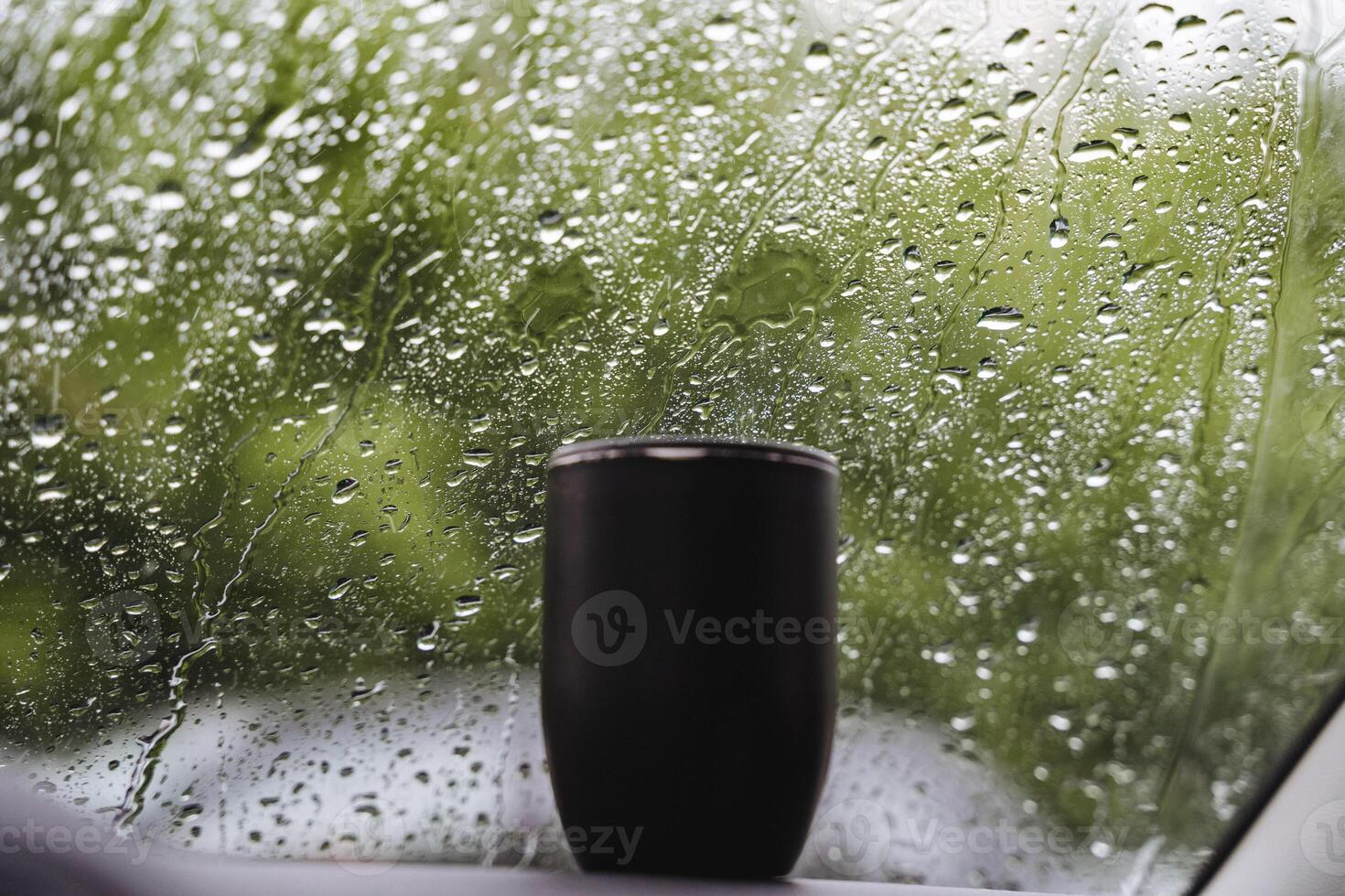 A cup by the window catches raindrops, merging indoor and outdoor elements, creating a tranquil atmosphere, connecting the room with nature. A blend of interior and exterior spaces photo