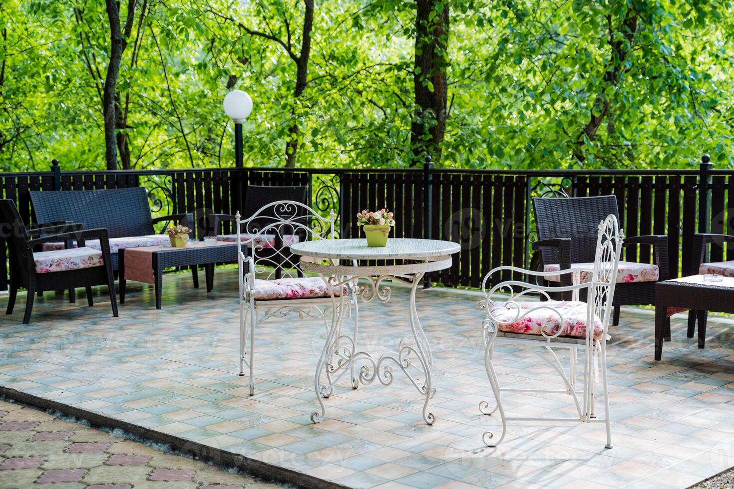 The serene outdoor patio includes a table, chairs, and trees, perfect for relaxation and outdoor activities. It offers a peaceful atmosphere for leisure and enjoyment in nature photo