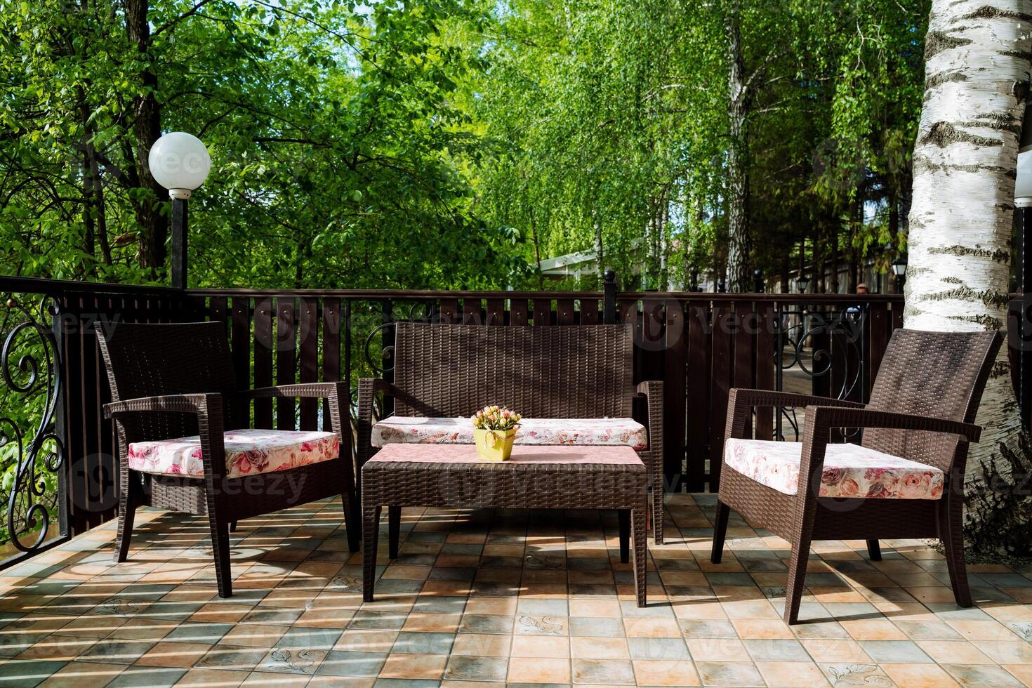 A beautifully furnished patio features a couch, chairs, table, and potted plant, creating a cozy outdoor space for relaxation and enjoyment in a natural landscape setting photo