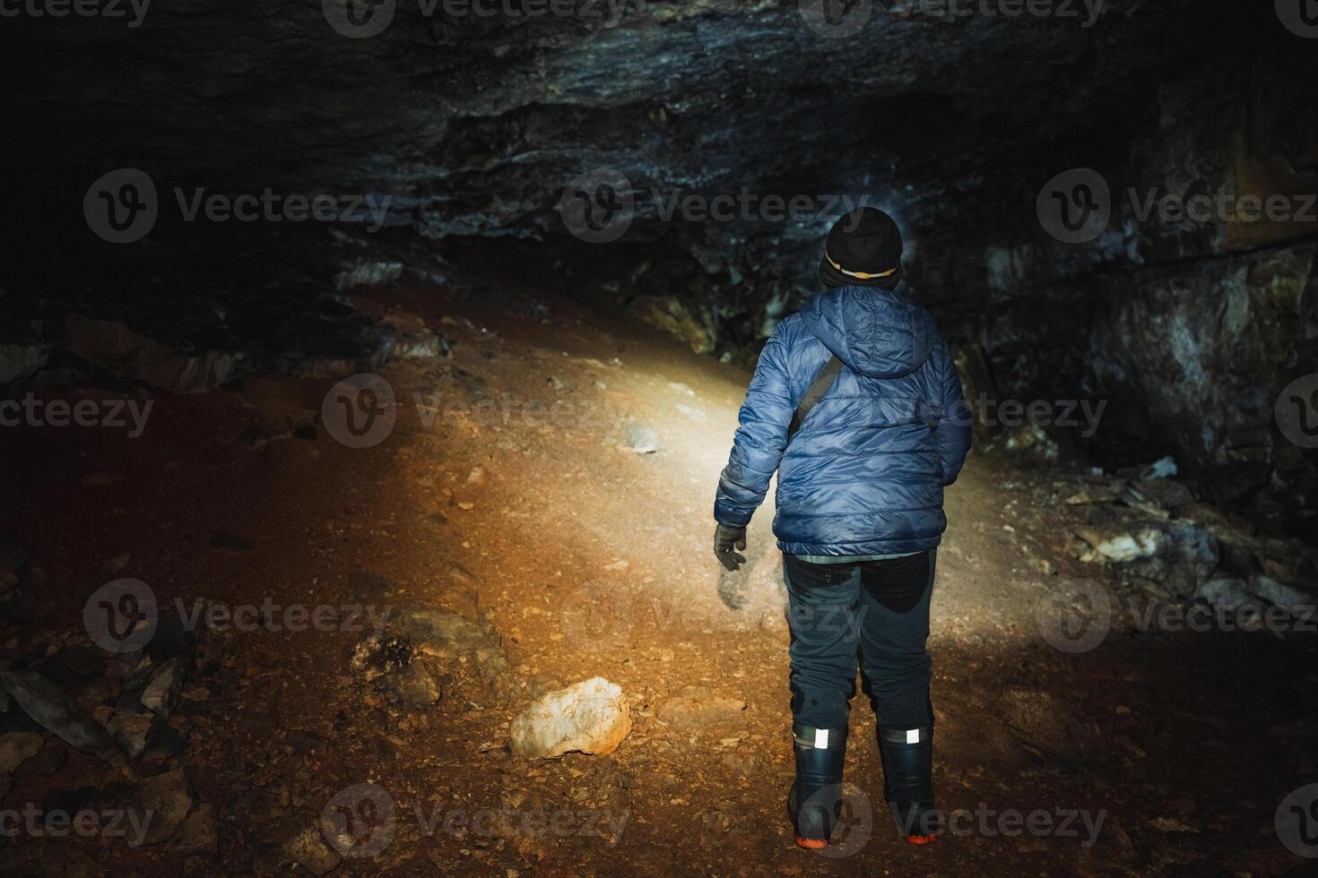 In a pitchblack cave, a courageous person remains steadfast, illuminating the fascinating beauty lurking within the shadows, thanks to the powerful beam of their bright flashlight photo