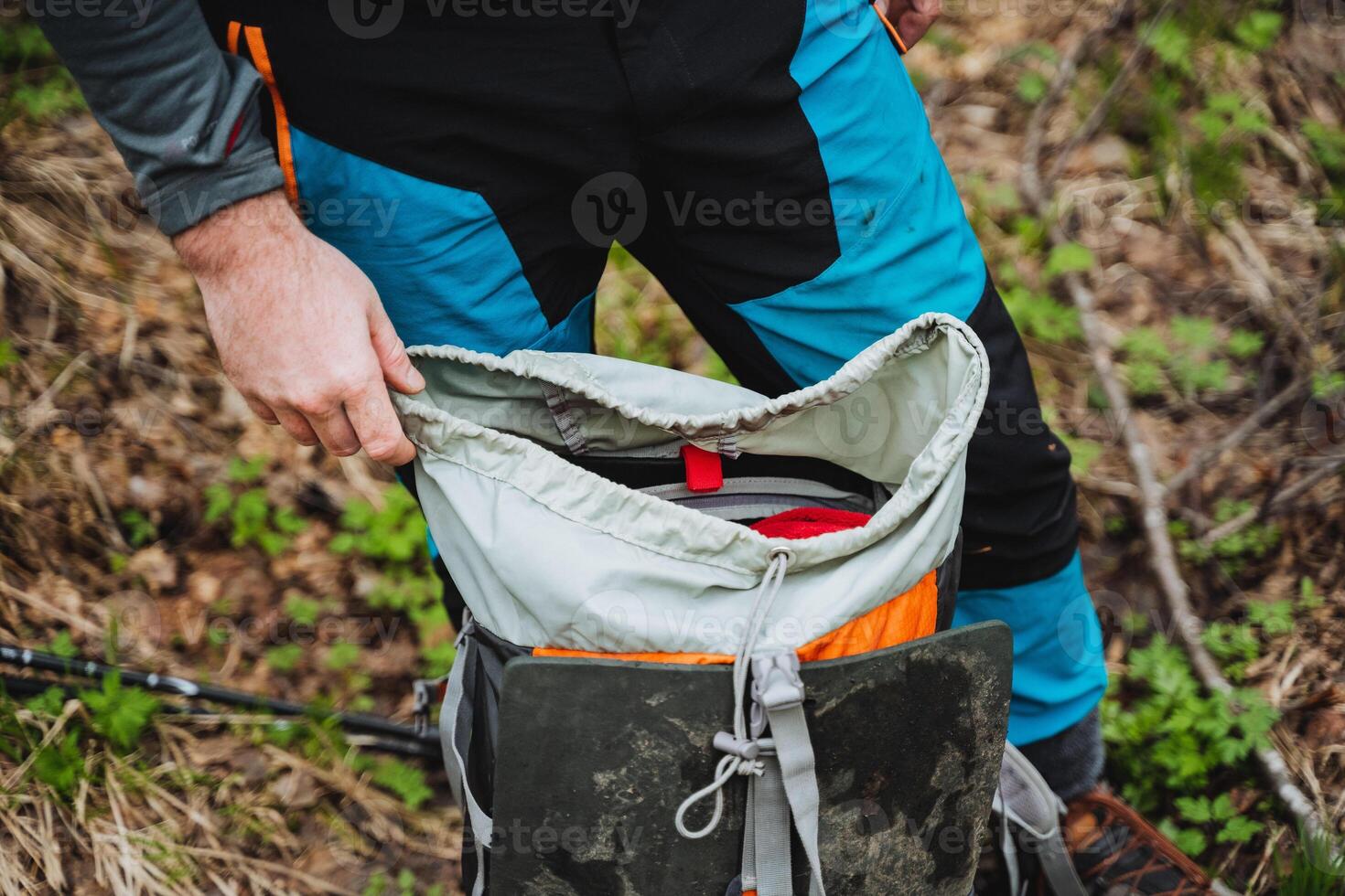 A traveler is retrieving a tire from the bag in the forest photo