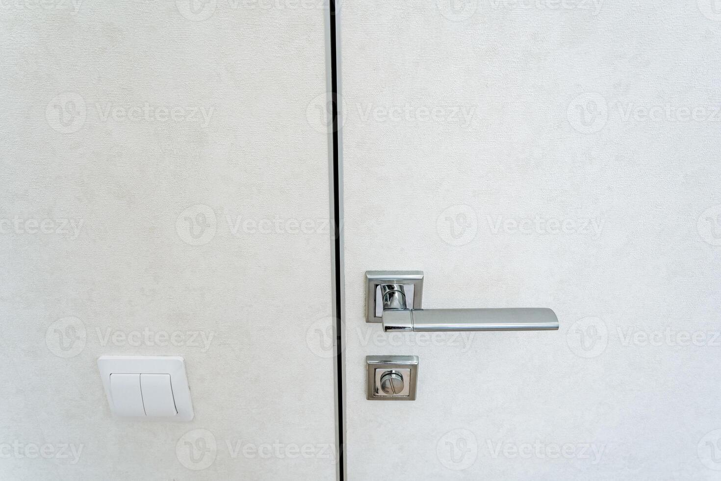 An intricate design and craftsmanship can be seen in the detailed image of a door handle on a white door, shown in a closeup view, emphasizing its elegance and structure photo