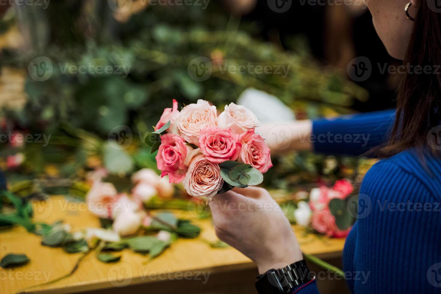 The woman is happily holding a bouquet of pink garden roses photo