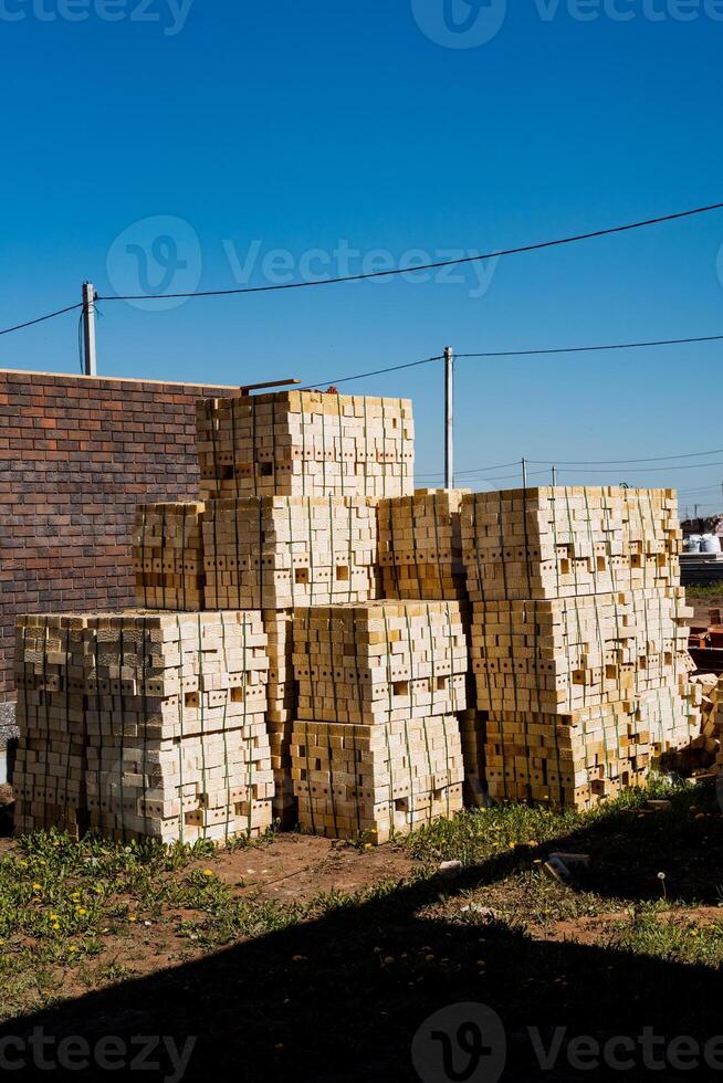 In a vast field, a stack of wooden crates is meticulously arranged, forming a structured heap. Each crate is placed carefully on top of the other, creating a precise and organized pile photo