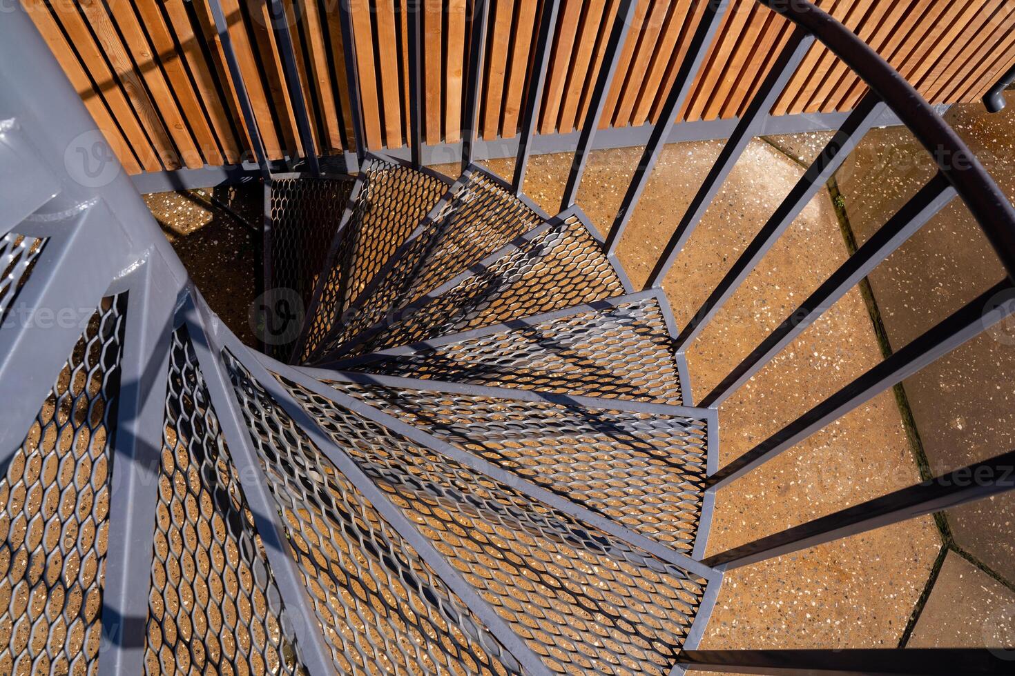 This stunning closeup of a spiral staircase features an exquisite metal railing, enhancing its aesthetic appeal and making it a remarkable visual delight from all angles photo