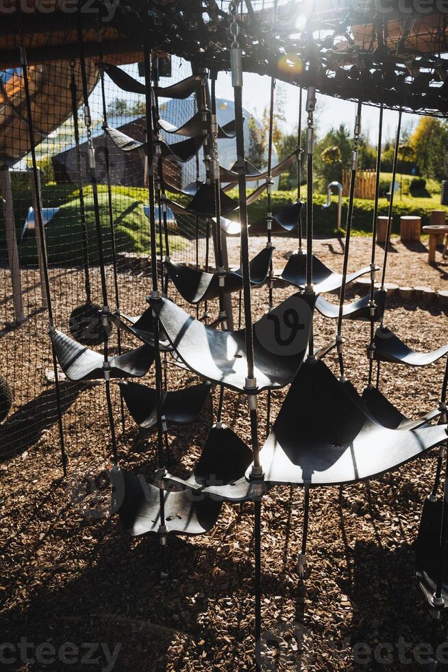 A large collection of various intricate metal sculptures is artistically hanging from a robust metal structure, creating a captivating visual display in the surrounding area photo