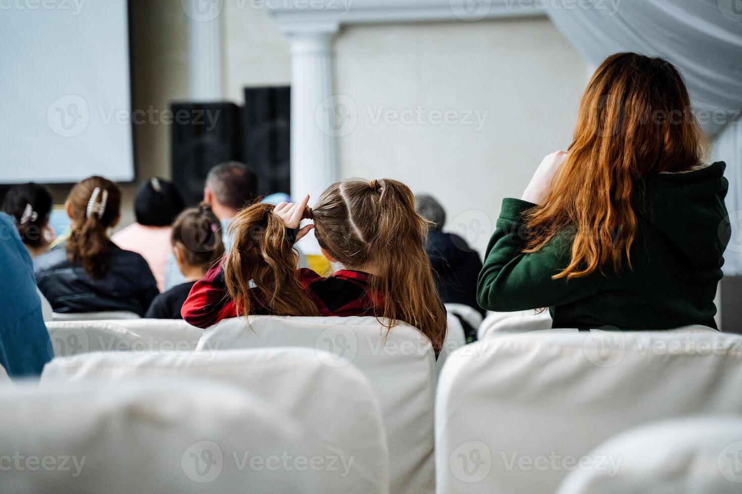 Crowd enjoying a movie together in comfortable theater seats photo