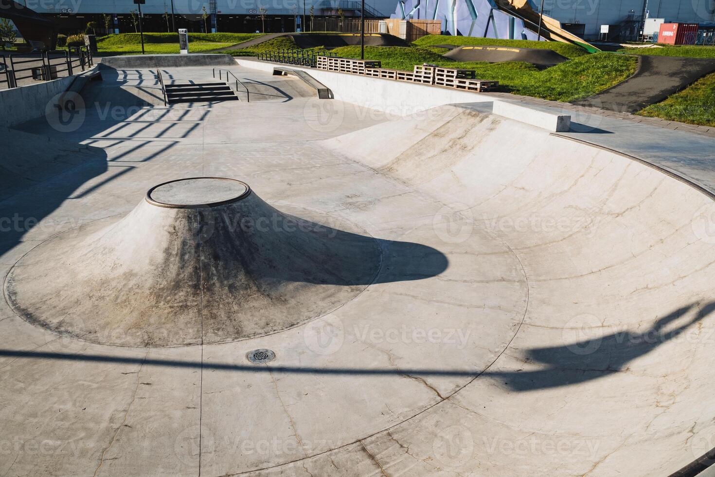 A talented skateboarder is performing an impressive trick on a ramp at a lively skate park, showcasing their skills and attracting the attention of onlookers who admire the scene photo