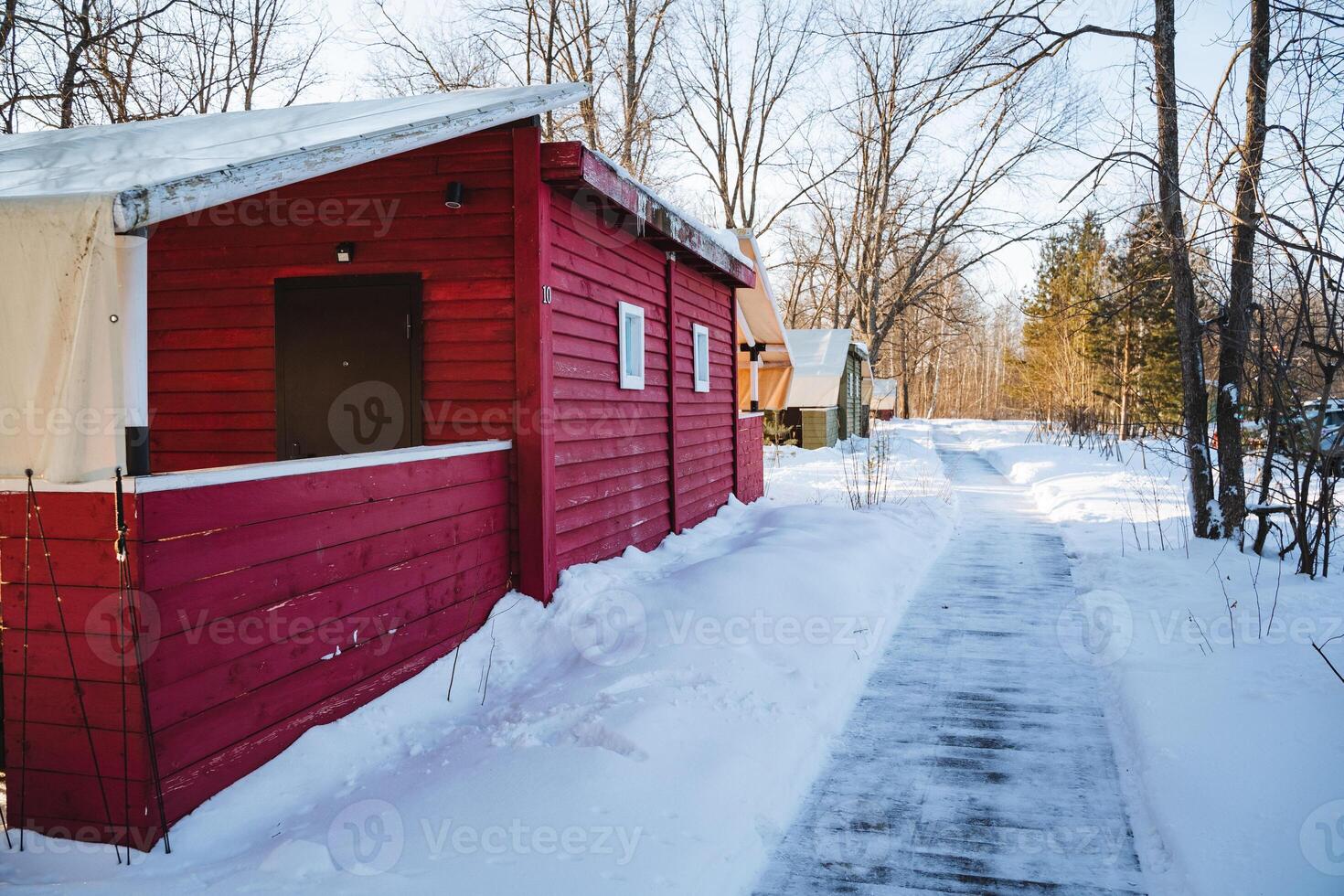 A snowy path leading to a red building photo