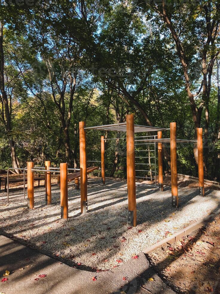 A beautifully crafted wooden playground is nestled among towering trees in a vibrant and lush forest, creating a peaceful and serene atmosphere for both visitors and local residents alike photo