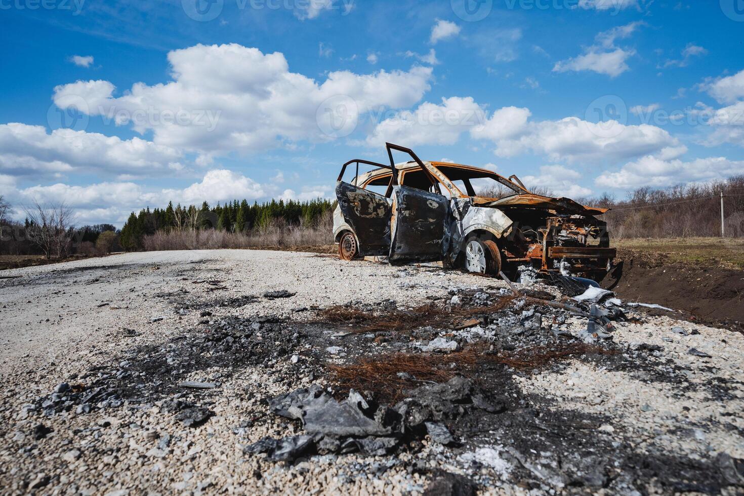 An accident on the road, a car burned to the ground, shelling of a vehicle, a battlefield, a burned-out car. photo