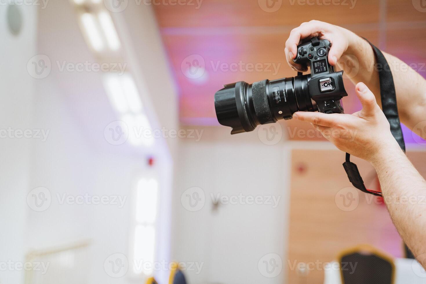 Person holding a digital camera with their fingers on the camera lens photo