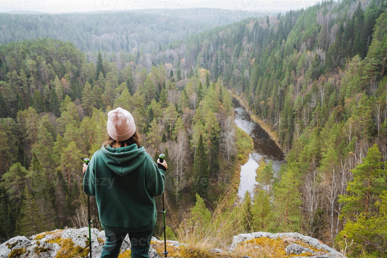 A breathtaking and stunning overlook of a serene, peaceful forested valley, where a hiker is joyfully enjoying the scenic view around them photo