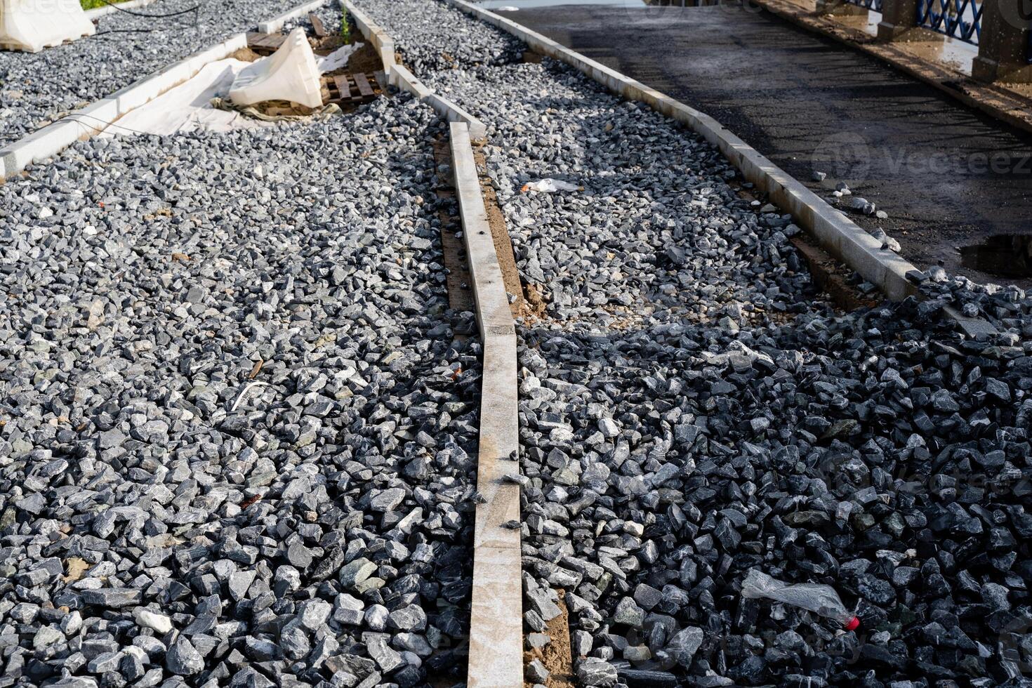 A strong and durable concrete curb placed atop a robust gravel pile creates a precise and defined boundary, which is crucial for successful roadside and landscape design projects photo