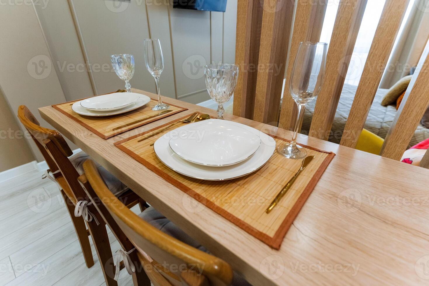 A beautifully crafted wooden dining table adorned with elegant plates, sparkling wine glasses, and a warm ambiance invited guests to enjoy their meal with an inviting atmosphere photo