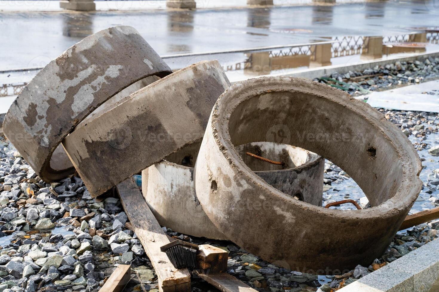 Three solid concrete rings are carefully stacked on top of one another, positioned securely on the ground surface, showcasing their sturdy construction and practical functionality photo