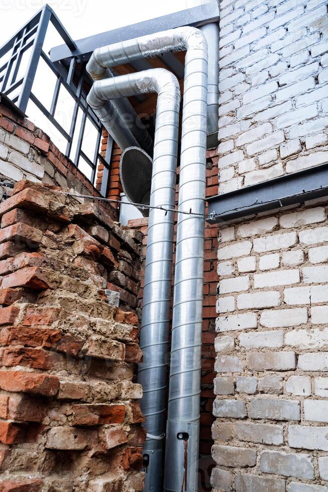 The structure features a sturdy brick wall with a securely attached metal pipe, showcasing a unique blend of materials that emphasize strength and practicality in modern construction photo