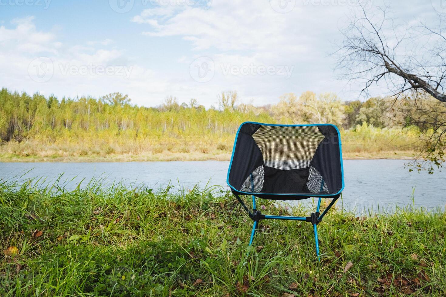 Imagine a portable camping chair by a tranquil river the perfect spot for relaxation, surrounded by natures beauty and serenity photo