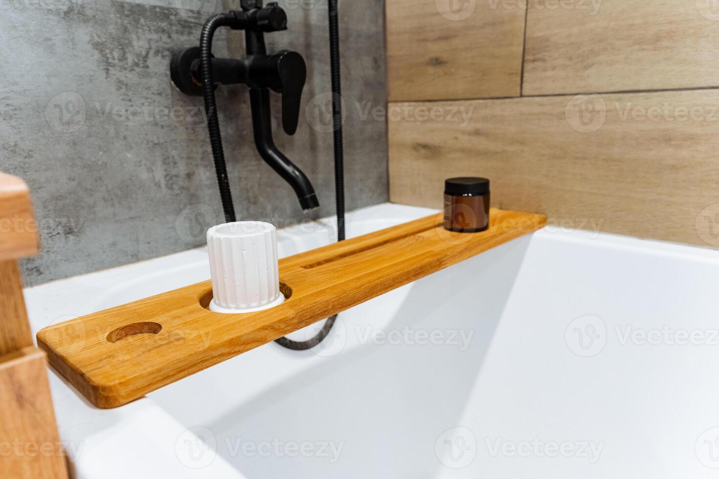 Discover the Elegant Bamboo Bathtub Tray, complete with a soothing candle and cup designed for your ultimate relaxation experience photo