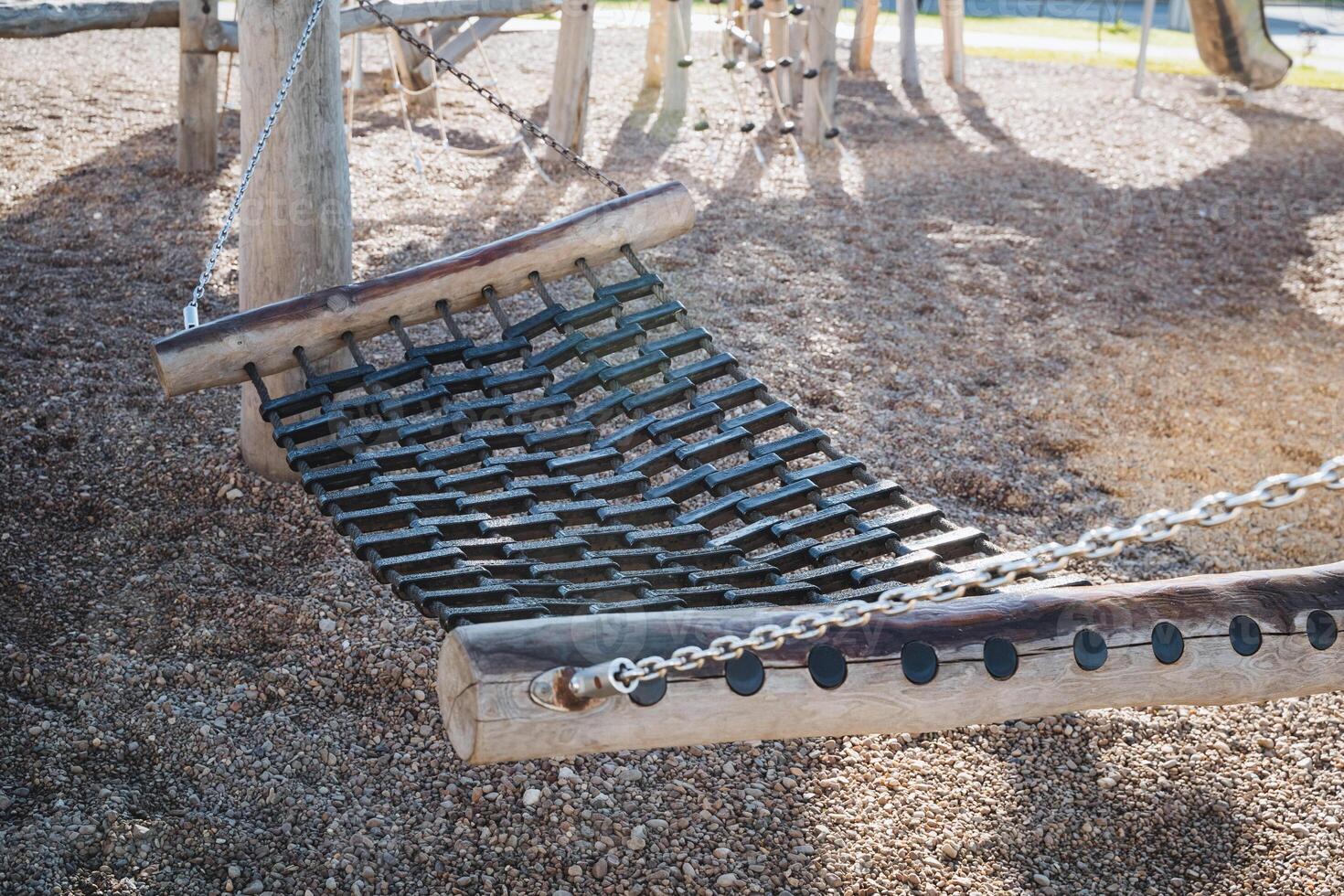 A comfortable hammock is carefully set up in the soft playground dirt, creating a unique and inviting space for relaxation and unwinding amidst the various fun outdoor activities available photo