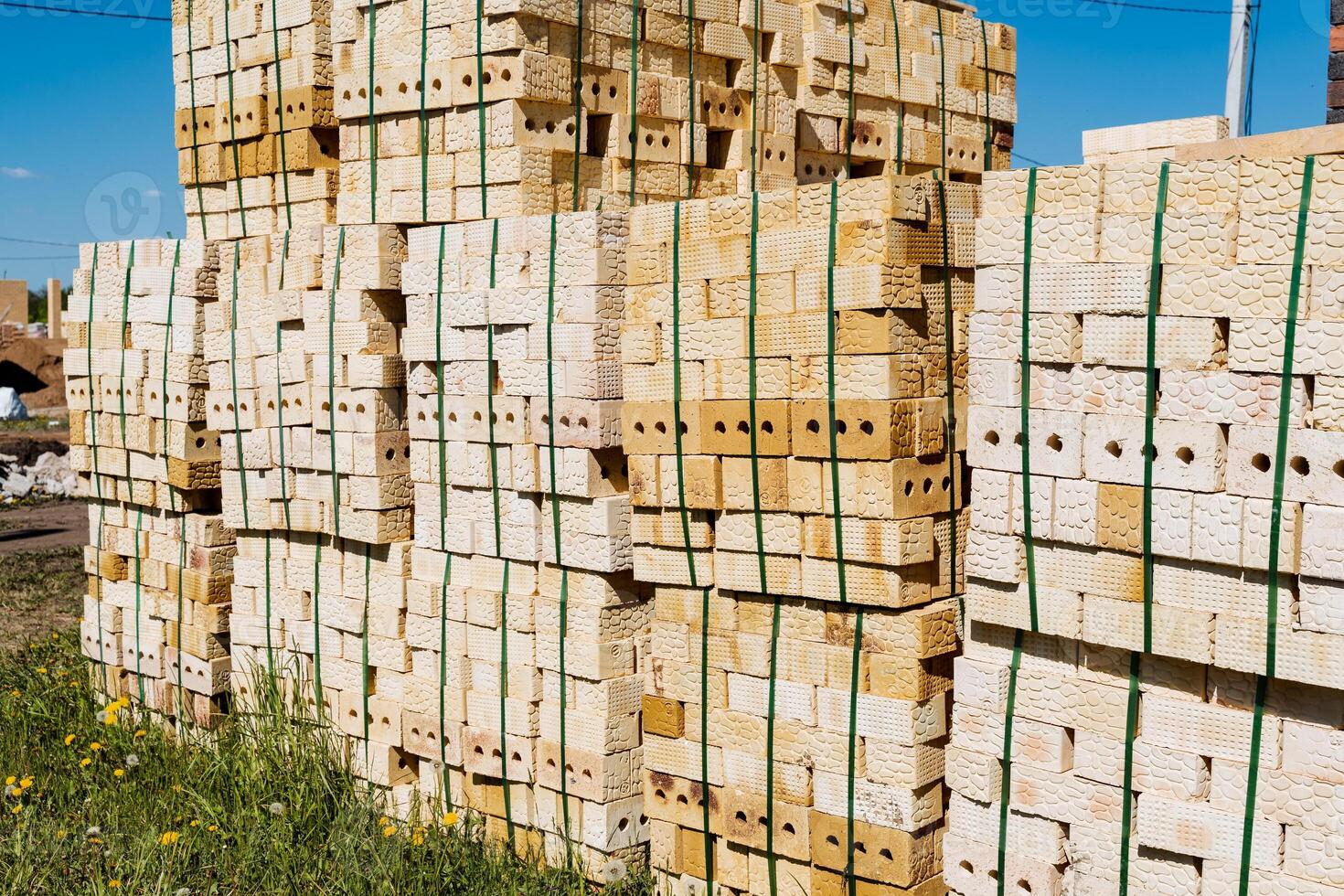 In the open field, a tower of bricks is meticulously arranged one on top of the other. This architectural feature contrasts beautifully with the vast sky in the background photo