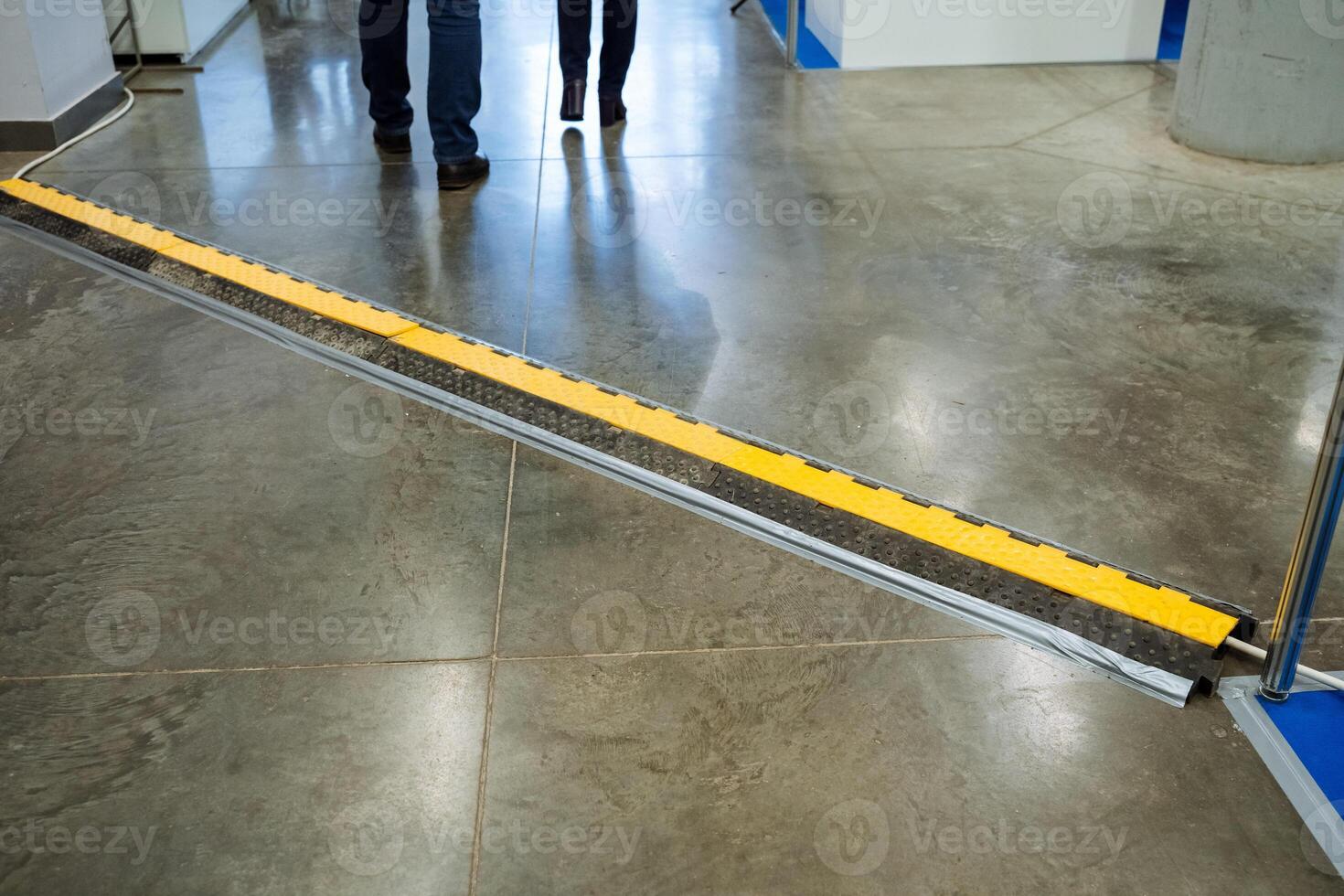 Two individuals are leisurely strolling down a long hallway that features a noticeable yellow stripe running along the floor, adding a vibrant touch to their surroundings photo