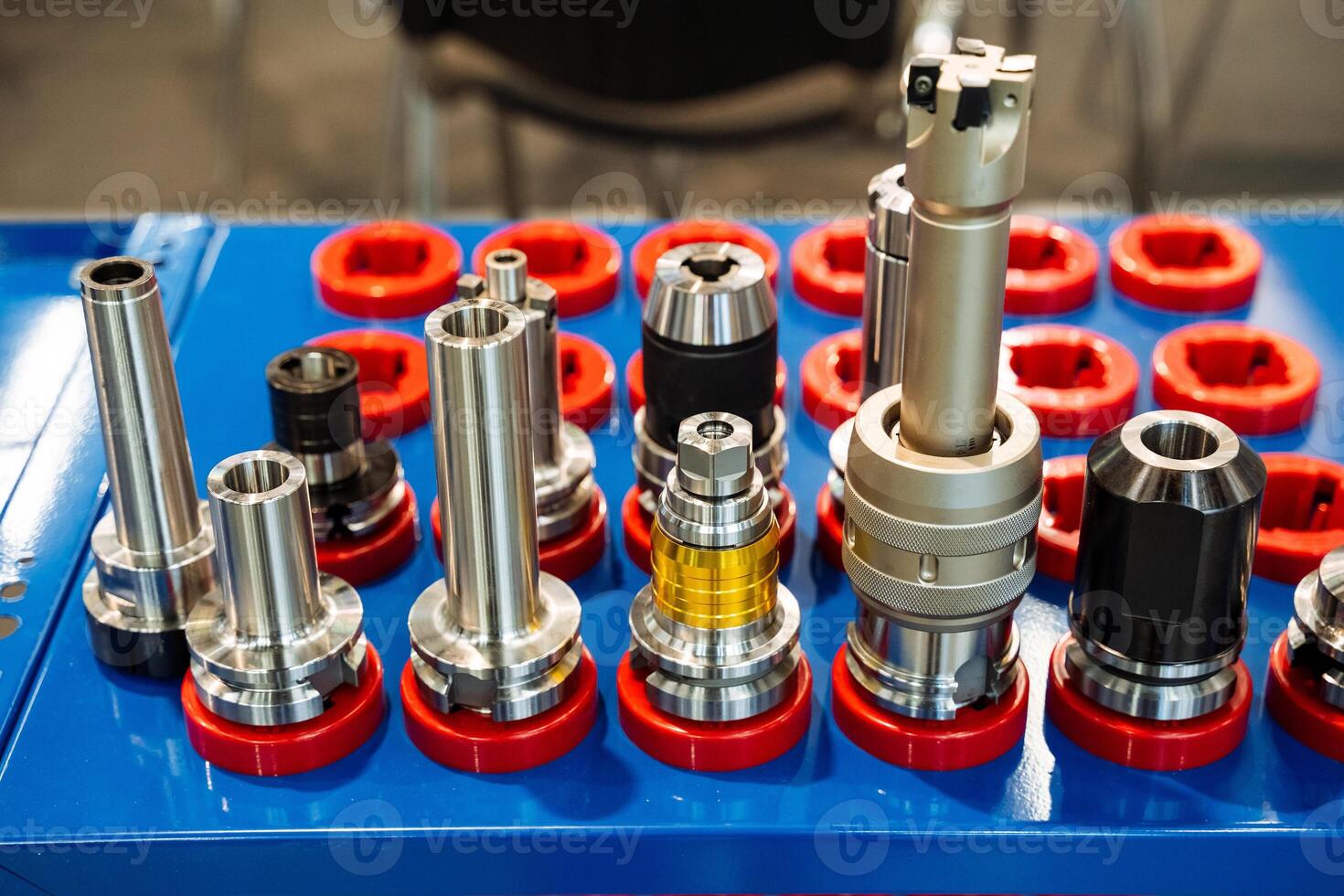 On a blue table, there is an assortment of various types of drill bits, each with a unique design and purpose, showcasing the diversity in tools used for drilling applications photo