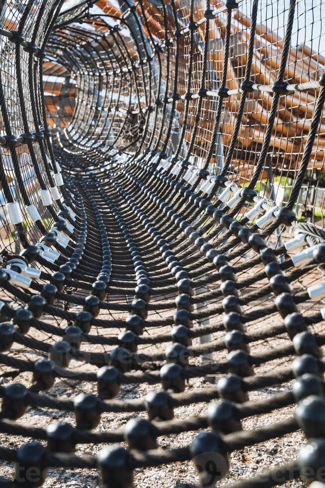 This is a closeup view of a ropes course situated within a park, showcasing the intricate designs and connections of the ropes and structures used for climbing and navigating photo