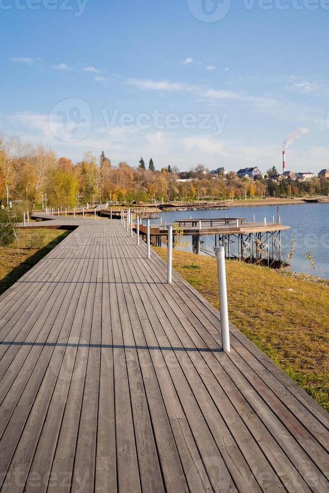 A wooden walkway leading to a lake in a park photo