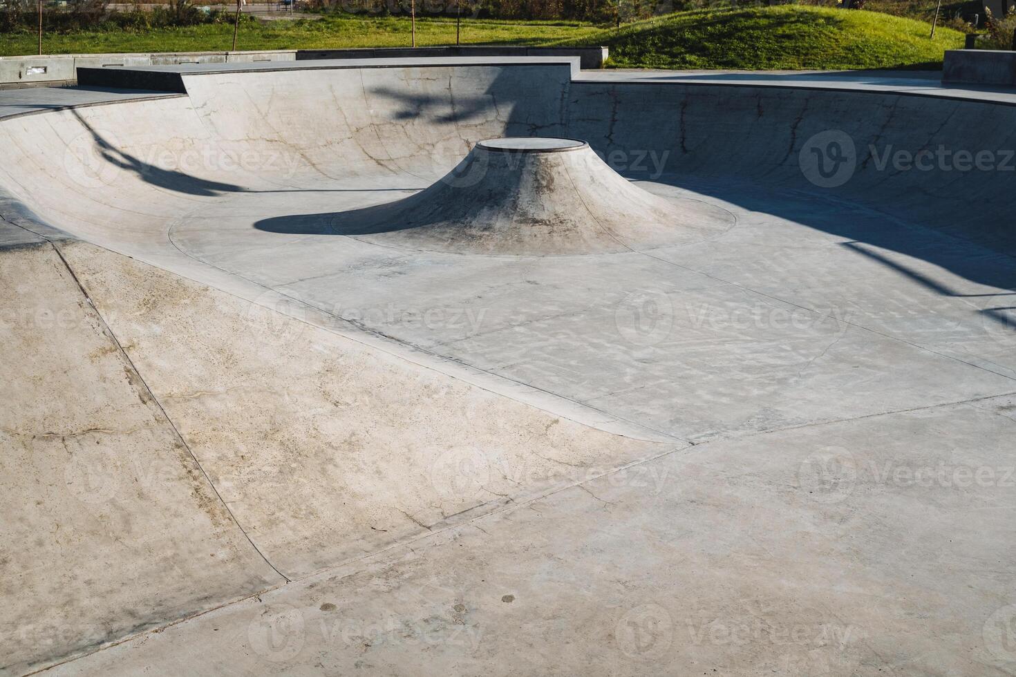 An expansive, empty concrete skatepark bowl showcasing a variety of unique features specifically designed for the enjoyment of skaters photo