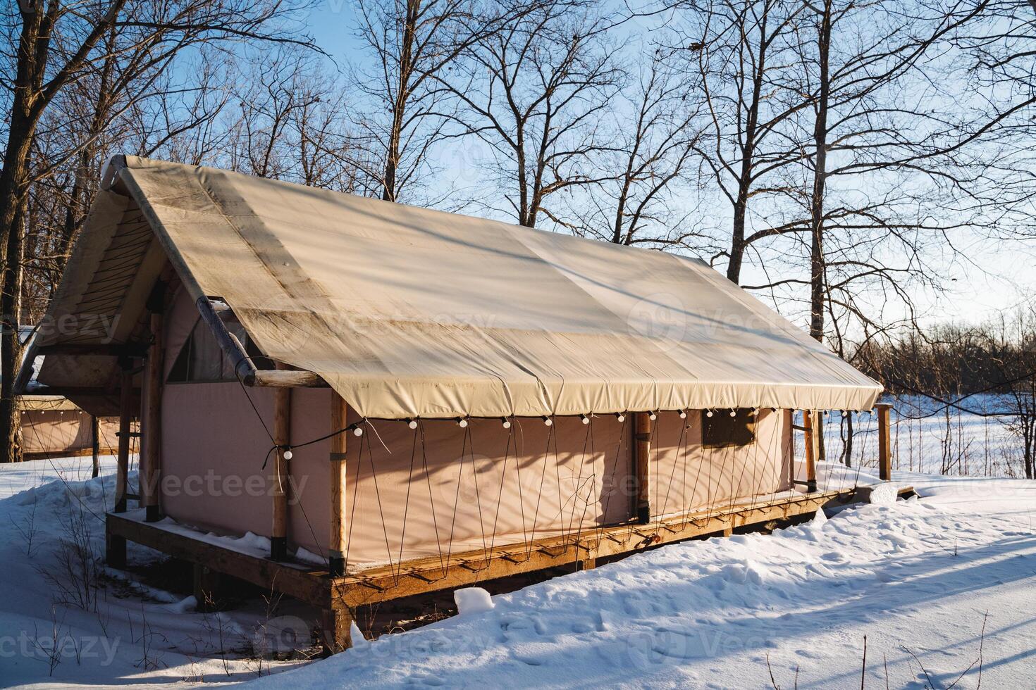 A quaint, small house is beautifully sitting right in the middle of a vast, snowy field, surrounded by the serene winter landscape, evoking a sense of tranquility and peace photo