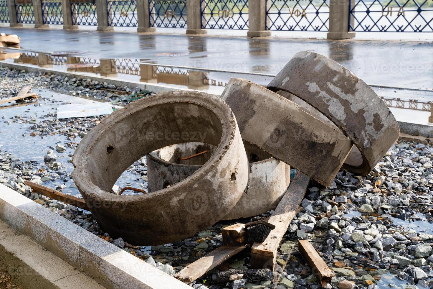 Abandoned and neglected concrete rings along with debris found throughout an urban setting or environment photo