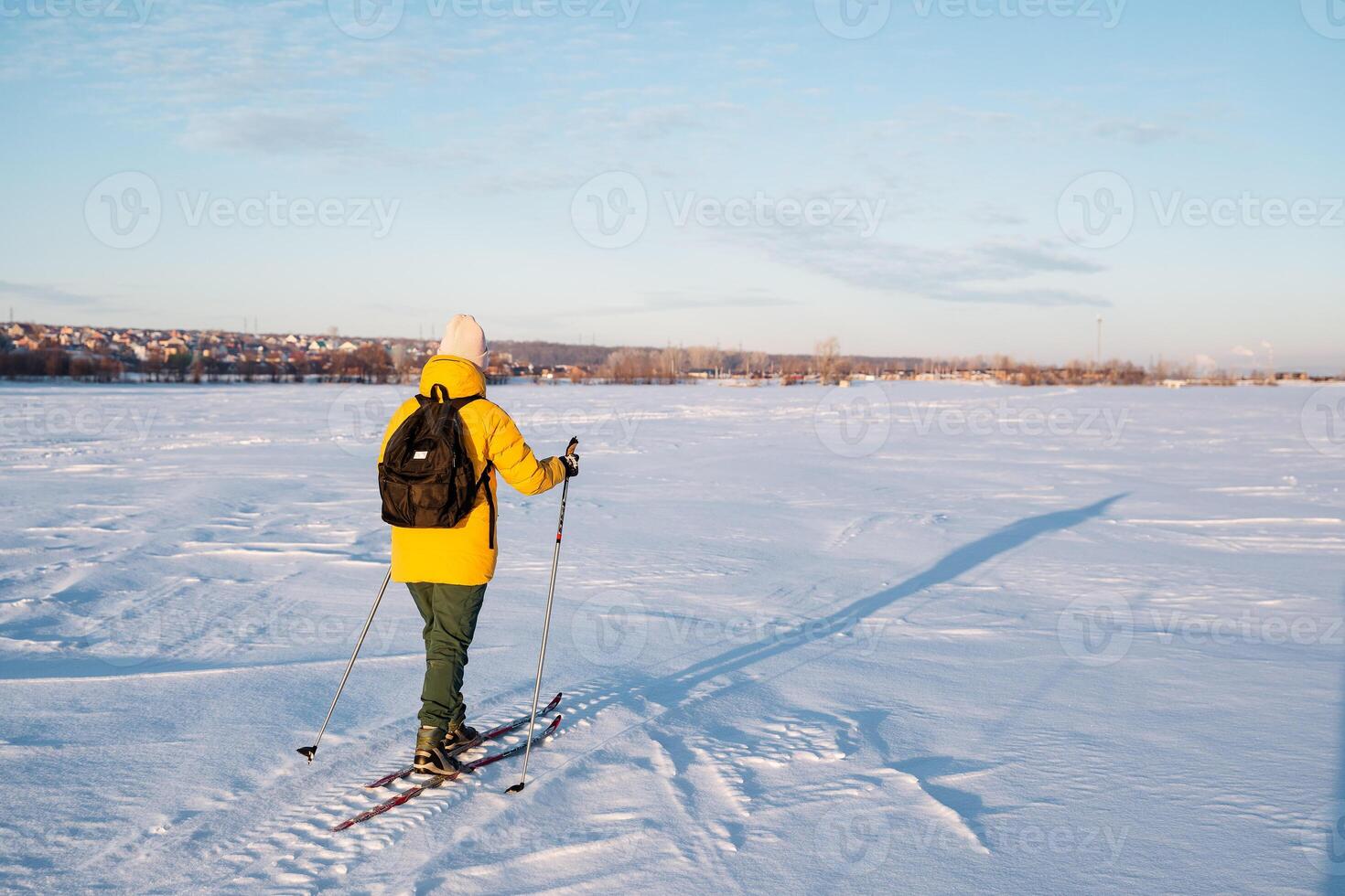 A man on skis walks on a snow-covered field, a woman travels with a backpack on a ski trip. photo