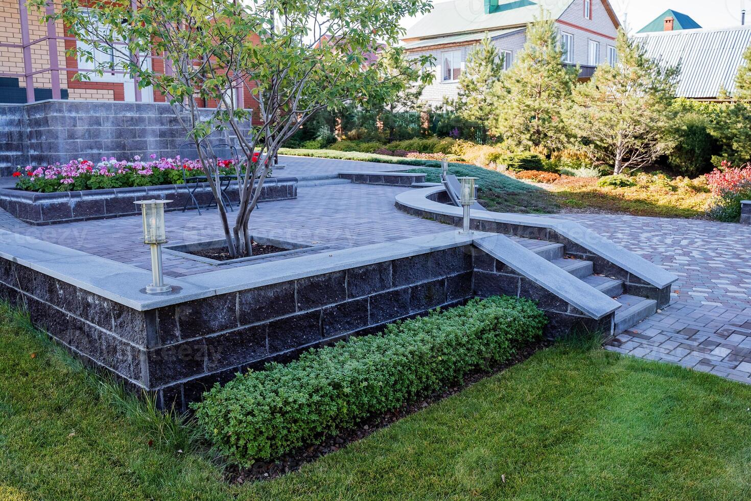 In the center of the beautiful garden, there stands a magnificent tree that adds charm and character to the surrounding area, providing shade and a home for various wildlife photo