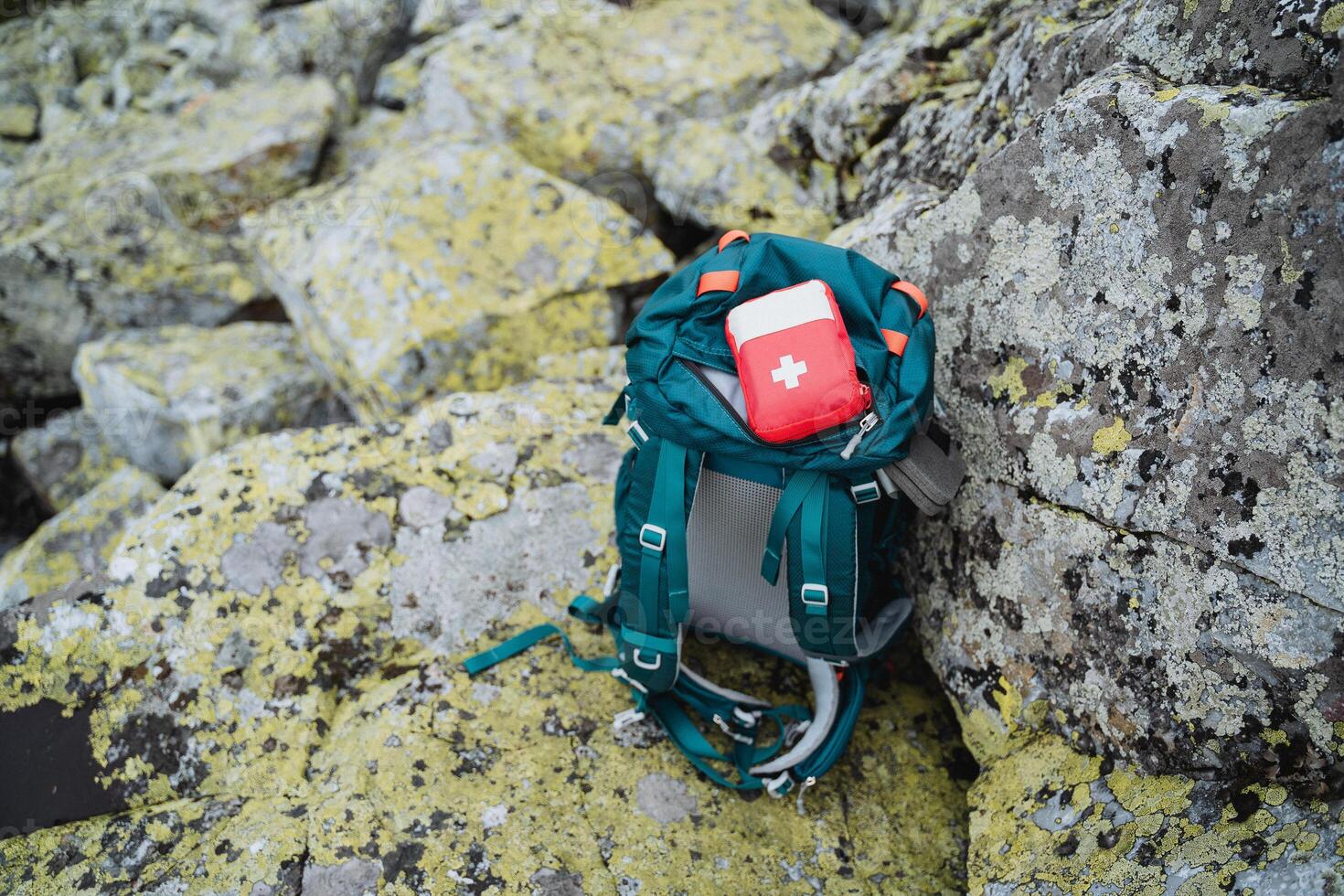 Traveler's backpack in the wilderness, first aid kit lying on backpack, hiking survival kit. Trekking in the mountains. photo