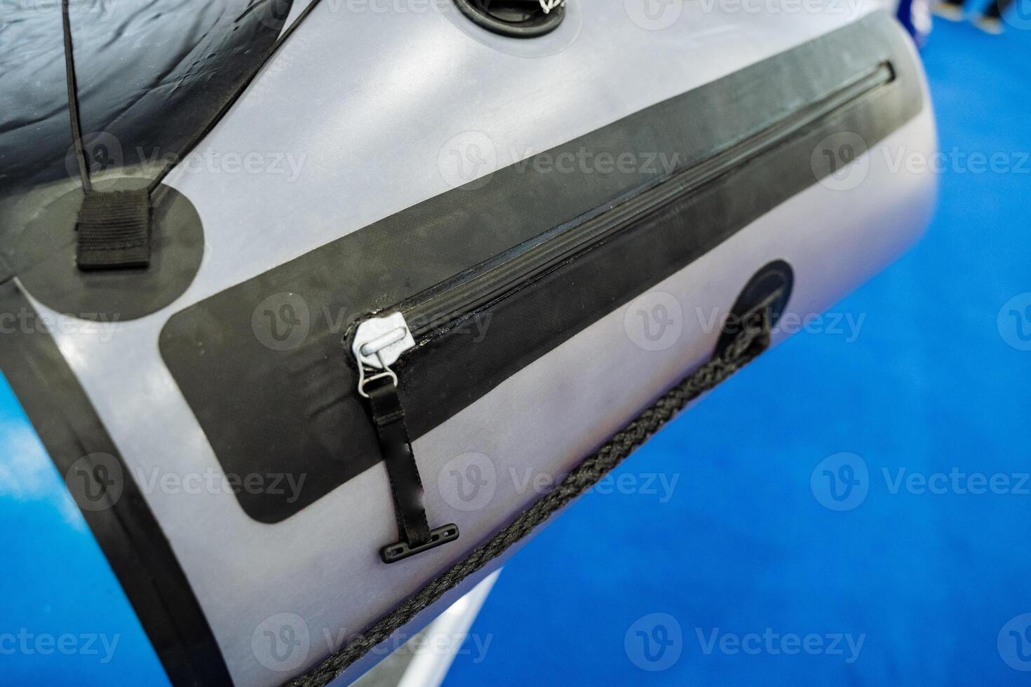 This striking image beautifully showcases a detailed closeup of a zipperadorned bag placed on a smooth, vibrant blue surface, emphasizing its intricate design elements and texture photo