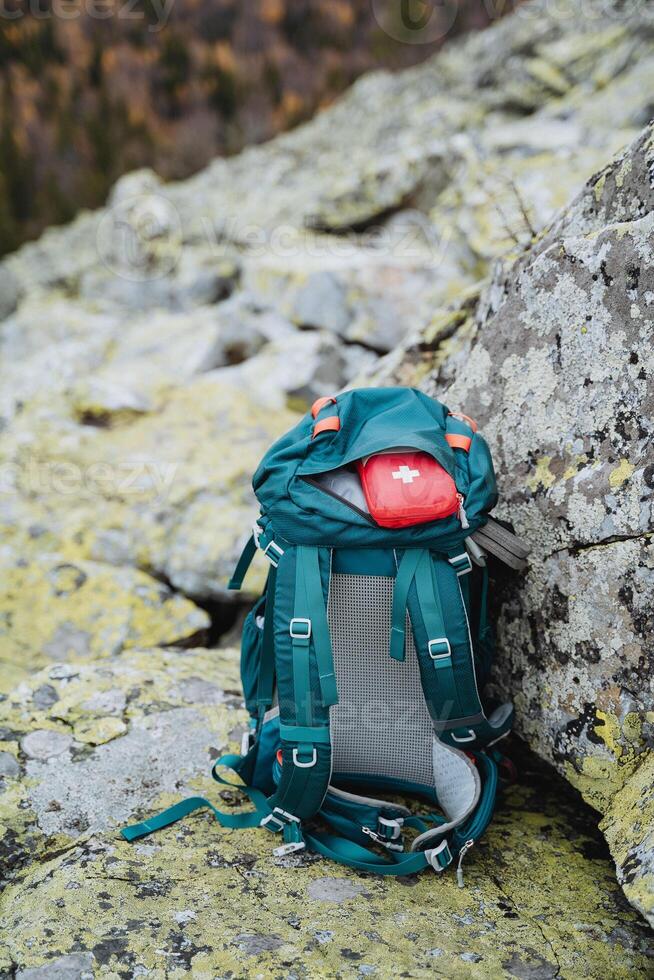 A small first aid kit is in the backpack, traveling through the mountains with a backpack, trekking on the rocks, tourist equipment on a hike. photo