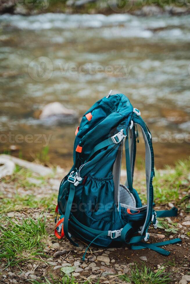 Explore the scenic Riverside Trail with a blue hiking backpack in a natural setting. Enjoy an outdoor adventure in the wild with essential gear and equipment for a daypack journey photo