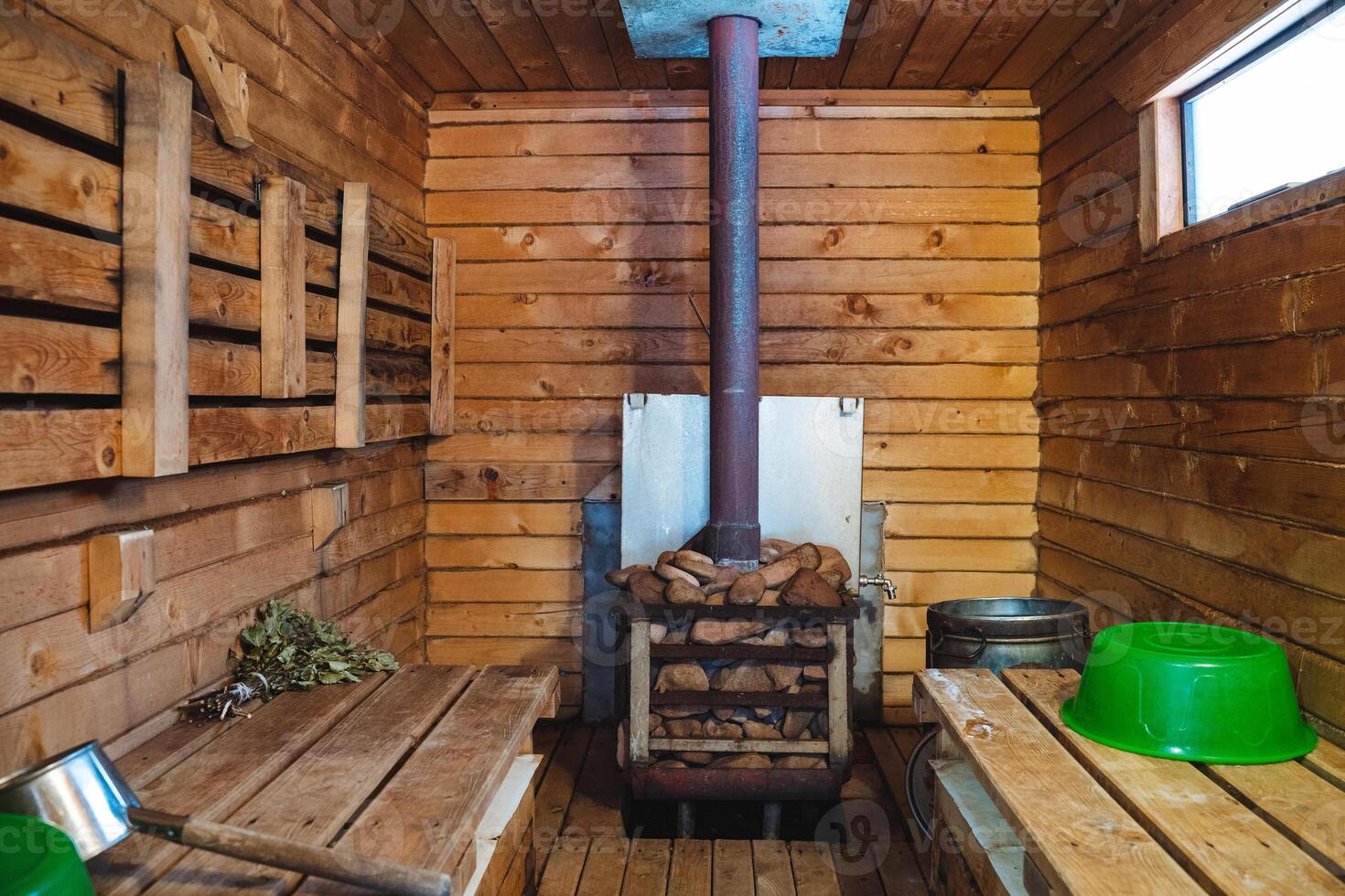 The wooden sauna features a cozy wood stove and aesthetically pleasing green bowls, creating a serene and inviting environment for relaxation and unwinding after a long day photo