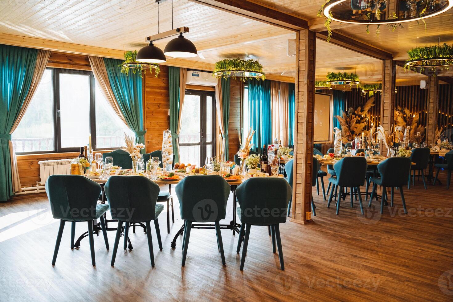 A beautifully decorated restaurant featuring tables and chairs that have been thoughtfully arranged for a delightful wedding reception celebration, creating a perfect ambience for the event photo