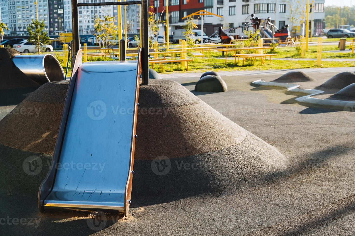 At a playground, there is a colorful slide sitting majestically on top of a hill, ready to provide hours of fun for children who come to play and enjoy outdoor activities photo