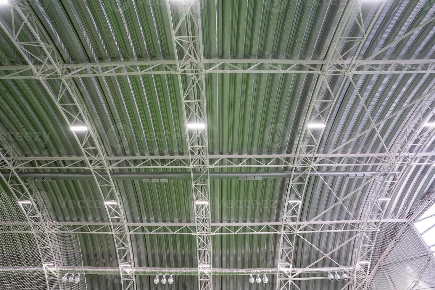 The ceiling of an extensive and spacious building that features a vibrant green roof, adorned with an array of bright lights that enhance its overall aesthetic and ambiance photo