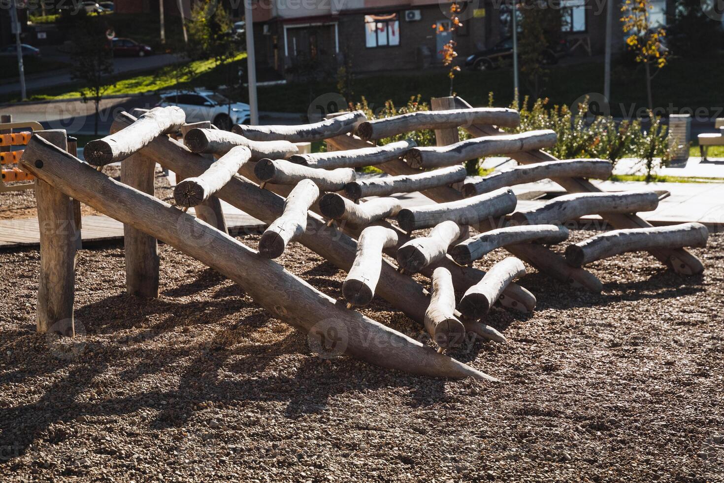 In a beautiful park, there exists an engaging playground constructed using a variety of logs and branches, offering a natural setting for fun and recreation for children and families photo