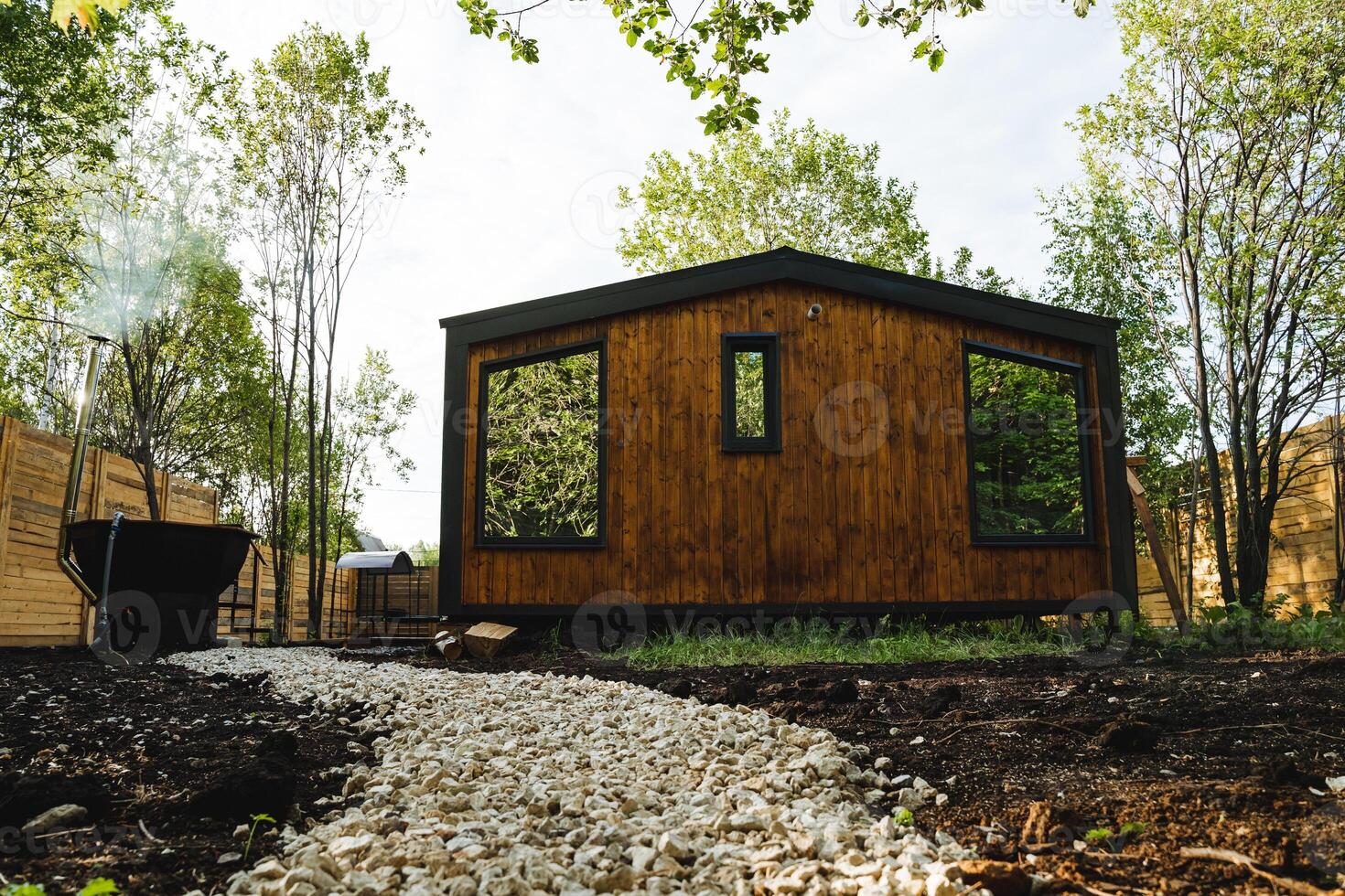 Nestled in the forest, a charming wooden cottage effortlessly merges into the natural surroundings, forming a serene atmosphere in sync with the trees and picturesque landscape photo