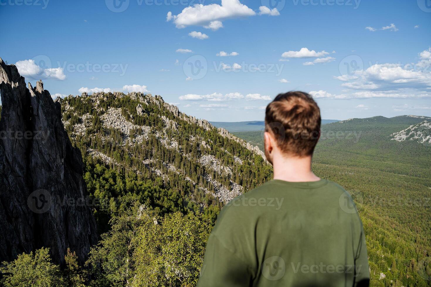 A hiker stands overlooking a breathtakingly majestic mountain view, immersed in the beauty of nature and the environment surrounding them photo
