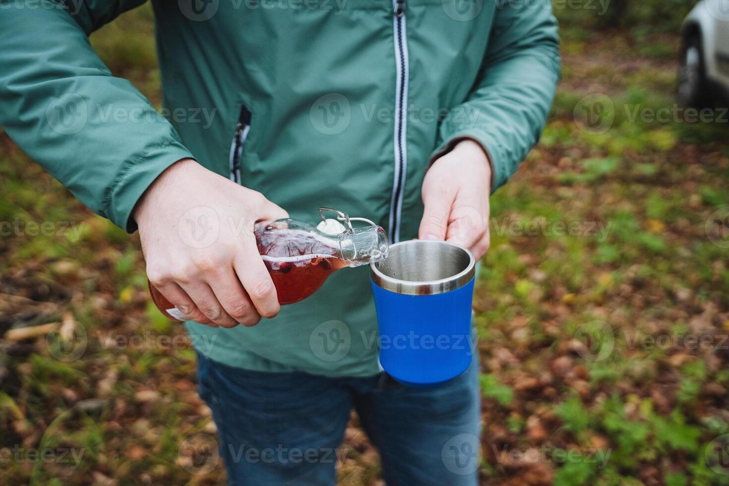 As I pour a refreshing beverage into my steel mug, Im surrounded by a breathtaking nature setting, enhancing our lovely outdoor adventure photo