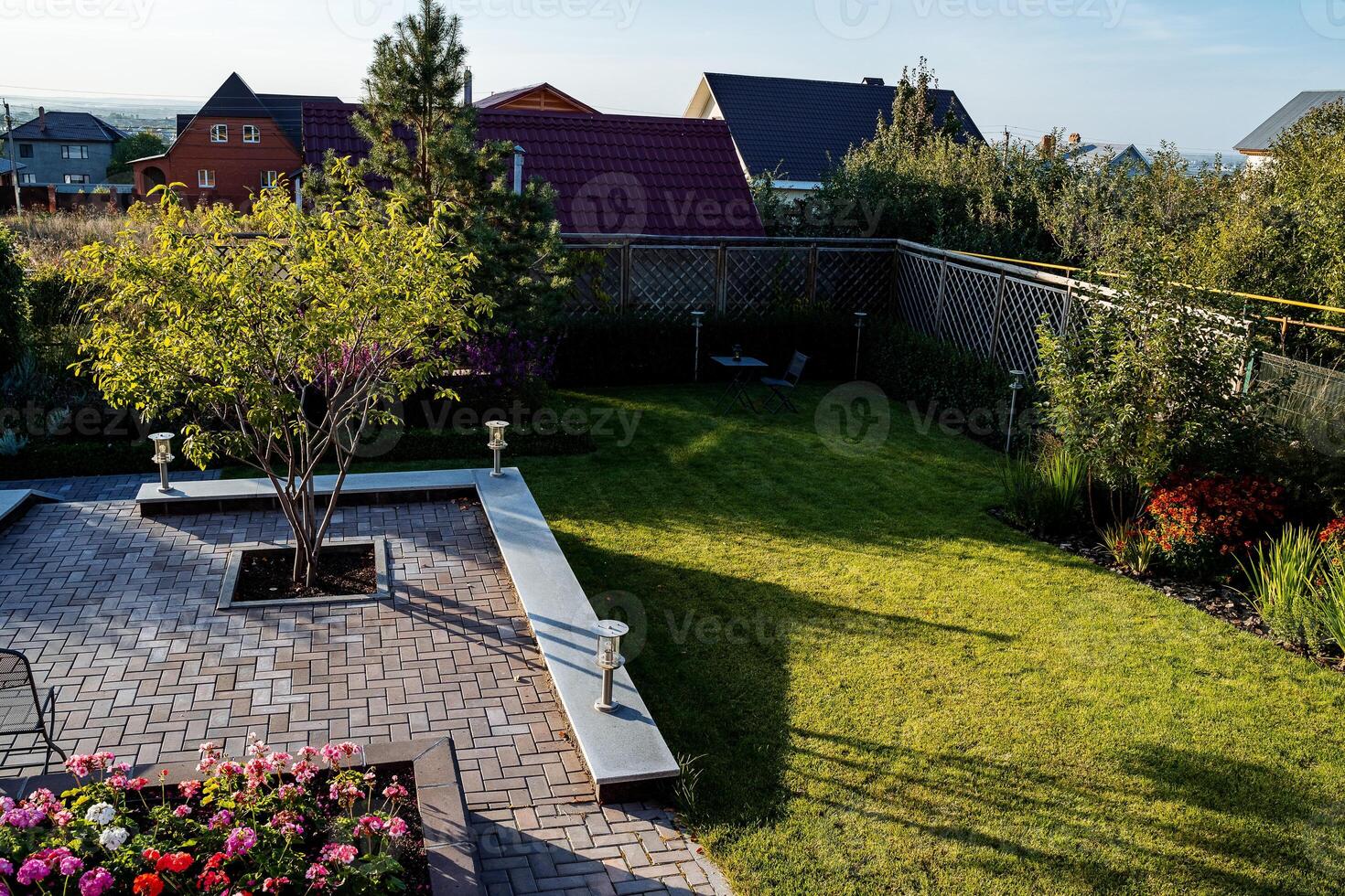 An expansive aerial view capturing a beautiful backyard featuring a vibrant and lush green lawn, alongside colorful flowers dotting the landscape, creating a serene outdoor space photo