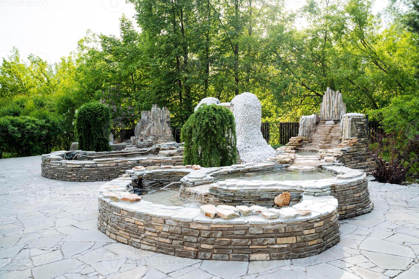 The Central Park area features a beautiful fountain surrounded by lush greenery, creating a tranquil oasis in the midst of the bustling city. It perfectly blends nature with urban life photo